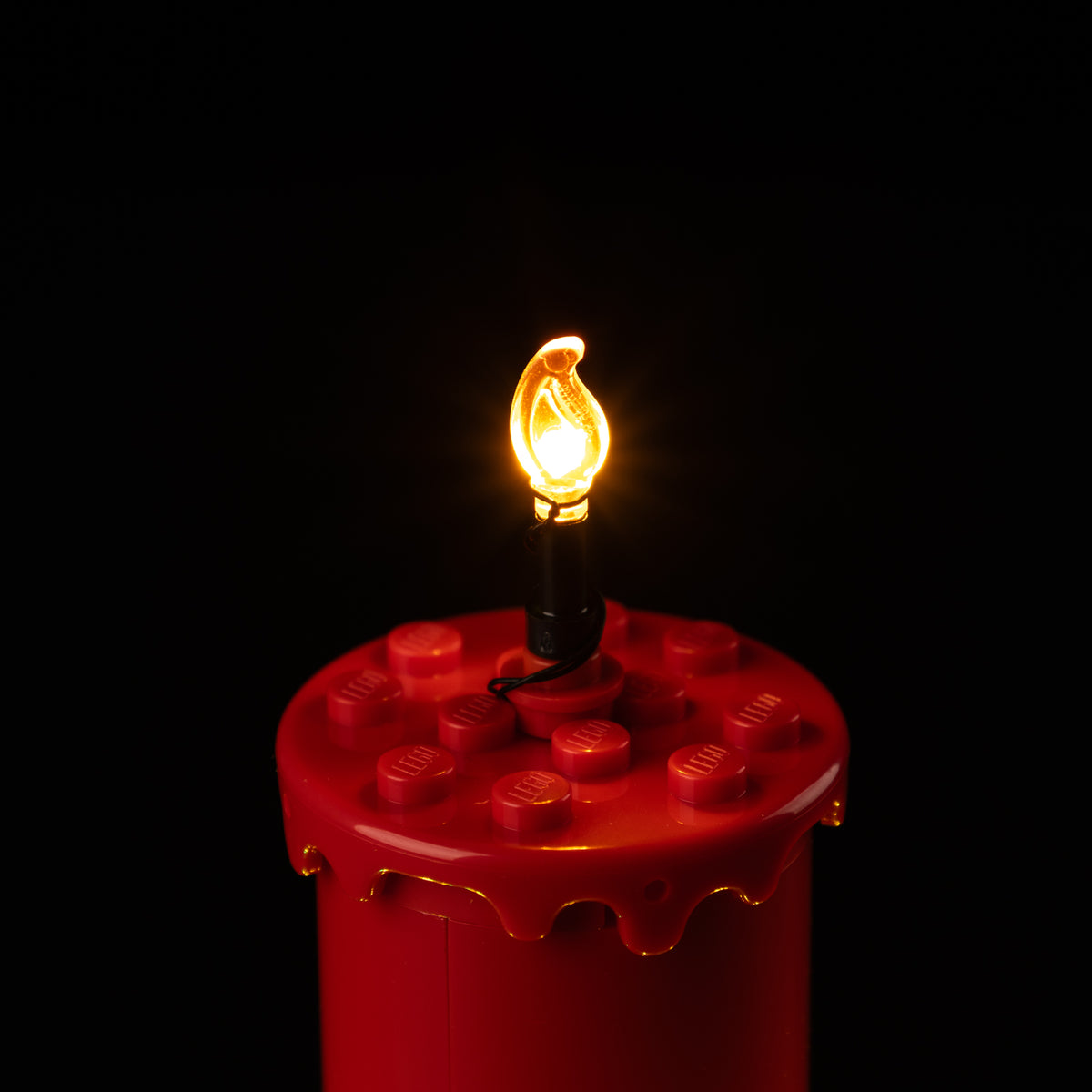 Real warm Game of Bricks LED inside the transparent flame piece above the red LEGO® candle.