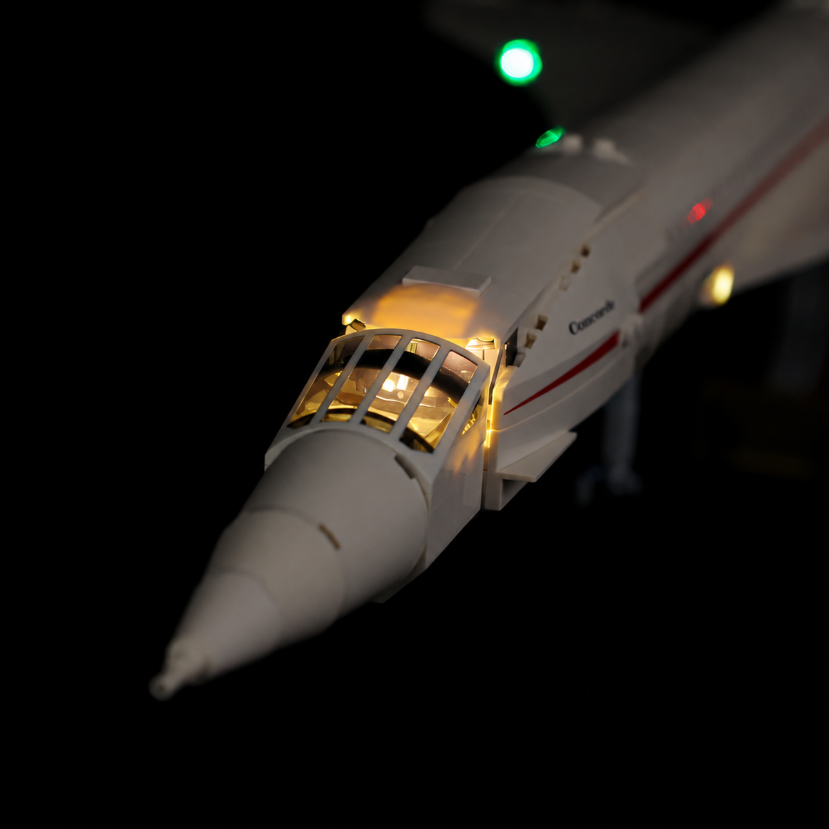 Warm cockpit illumination on the real LEGO Concorde 10318 model with its droop nose and white brick fuselage.