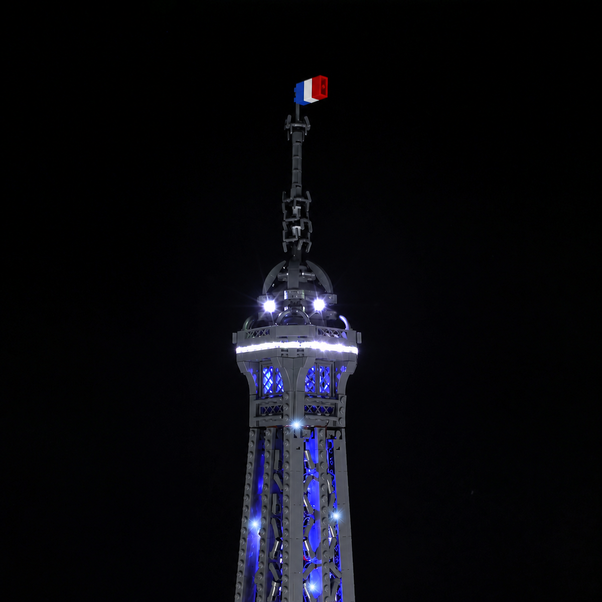 The French flag and illuminated summit of LEGO Eiffel Tower 10307 with the Game of Bricks Standard light kit.
