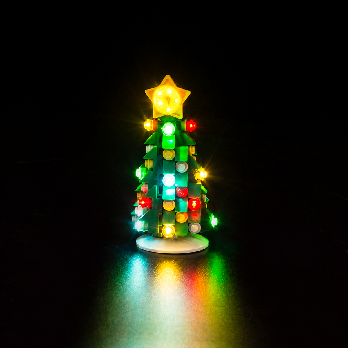 Christmas tree from LEGO® Elf Club House 10275 with colourful Game of Bricks lights against a dark background