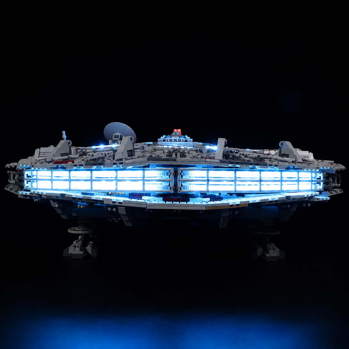 Low rear view of LEGO Millennium Falcon 75192 with a blue-white engine strip reflecting on a dark surface.