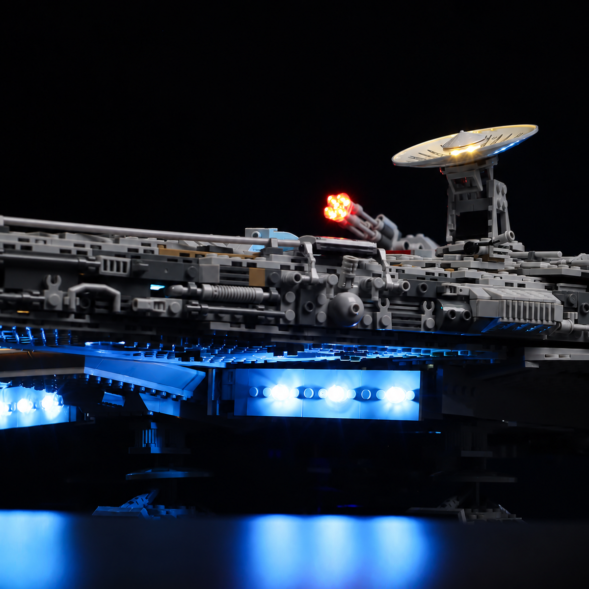 Low side view of LEGO Millennium Falcon 75192 showing blue underbody lights reflected on the surface below.