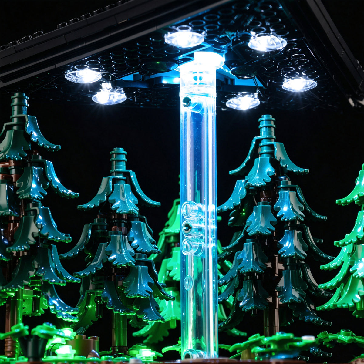 White LEDs beneath the LEGO UFO, a cyan-lit transparent column and green-lit woodland.