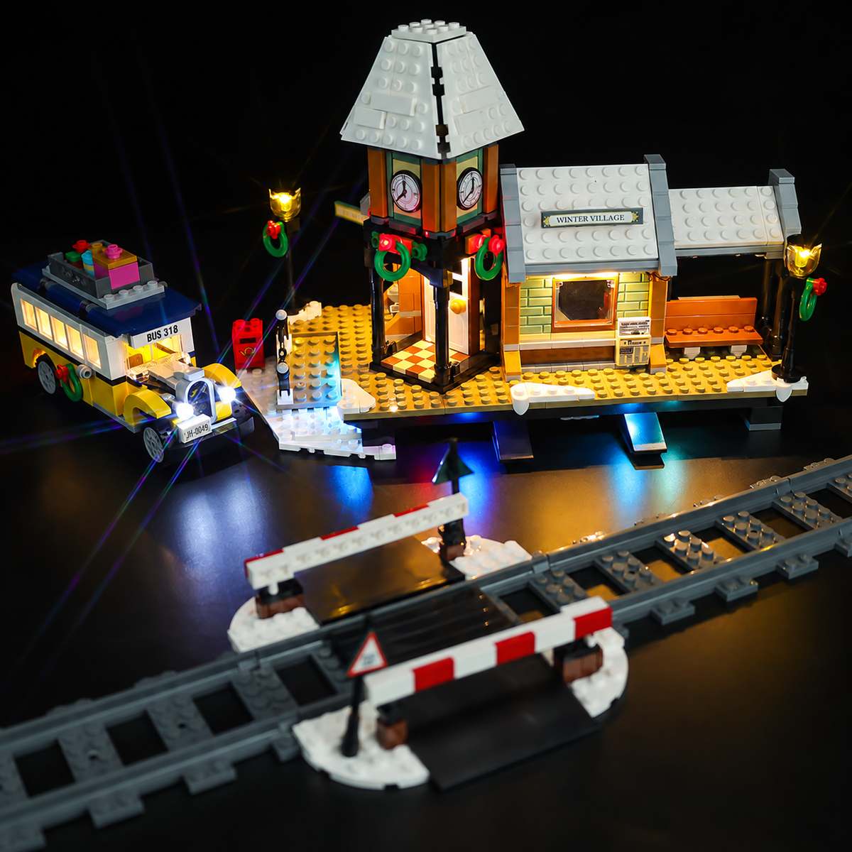 LEGO® Winter Village Station 10259 front view showing the clock tower, yellow bus, lamps and snowy platform.